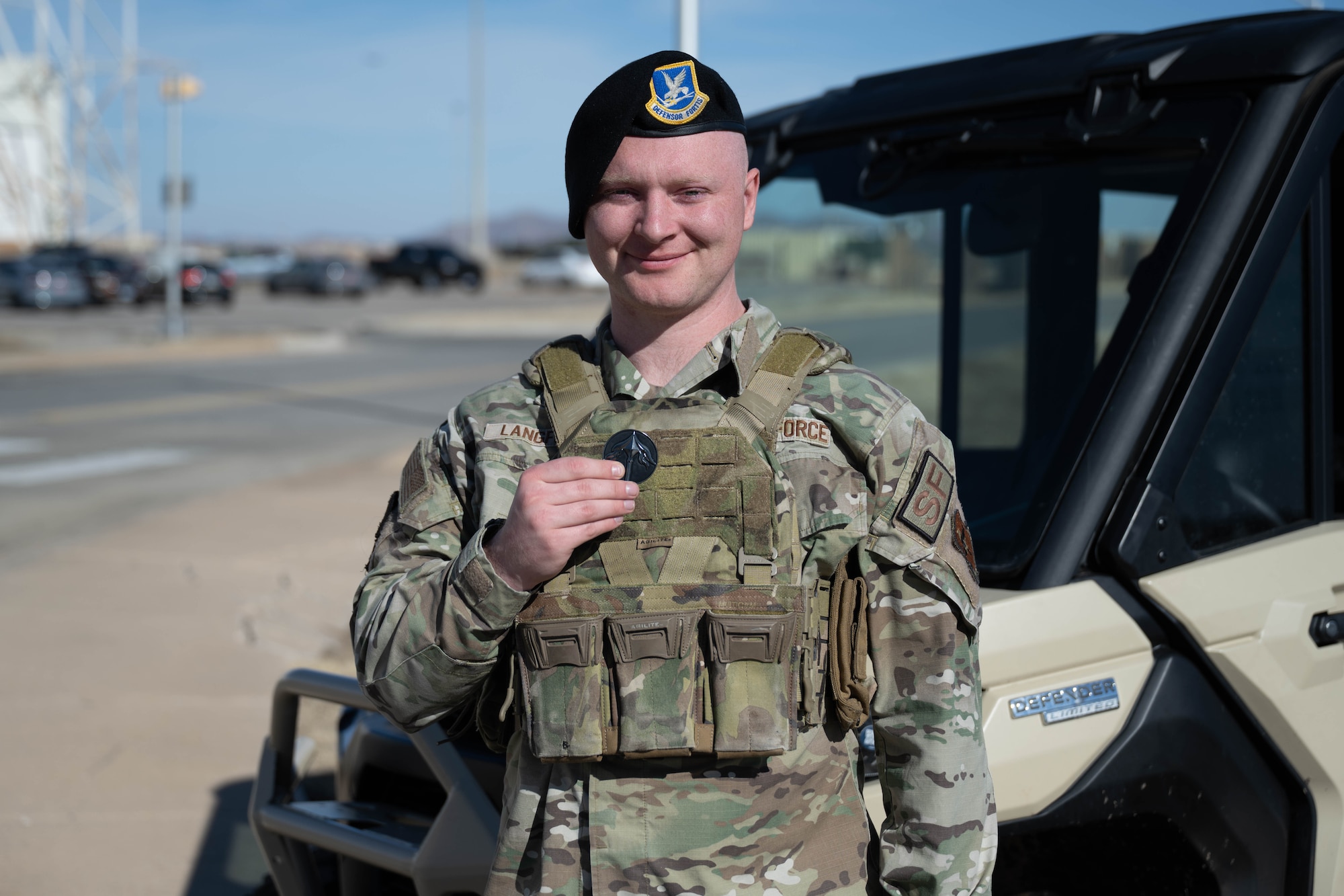 U.S. Air Force Senior Airman Roy Langford, 97th Security Forces Squadron, base defense operations center controller, displays his coin at Altus Air Force Base, Oklahoma, Feb. 11, 2026. Langford was coined for exhibiting courageous acts of valor in the face of grave danger and adversity when he saved an unconscious driver from a burning vehicle. (U.S. Air Force photo by Emma Wright)