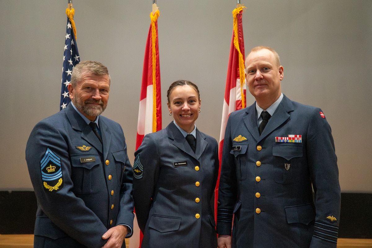 Royal Danish Air Force Master Sgt. Nanna Christiansen, center, a Noncommissioned Officer Academy student, celebrates her graduation with two of her commanding officers at Joint Base Elmendorf-Richardson, Alaska, Feb. 10, 2026. Canadian and Danish leadership attended the graduation in support of their members who were included in NCOA Class 26-A. The collaboration with partner nations strengthens the impact of the curriculum by integrating the experience and perspective of foreign military operatives to enhance interoperability. (U.S. Air Force photo by Airman 1st Class Theodore Gowdy)