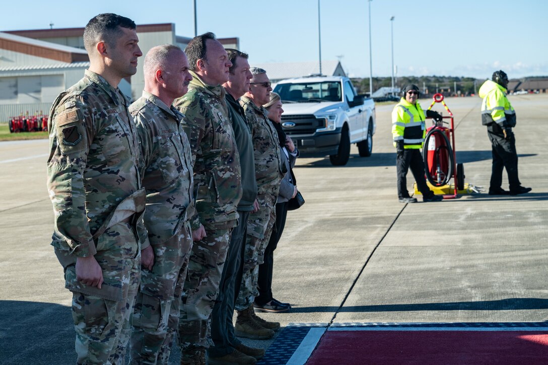 Line of 5 military members standing at attention outside