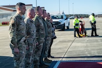 Line of 5 military members standing at attention outside
