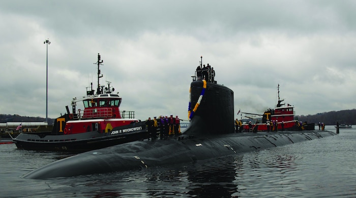 U.S. Navy nuclear submarine being guided by tugboats