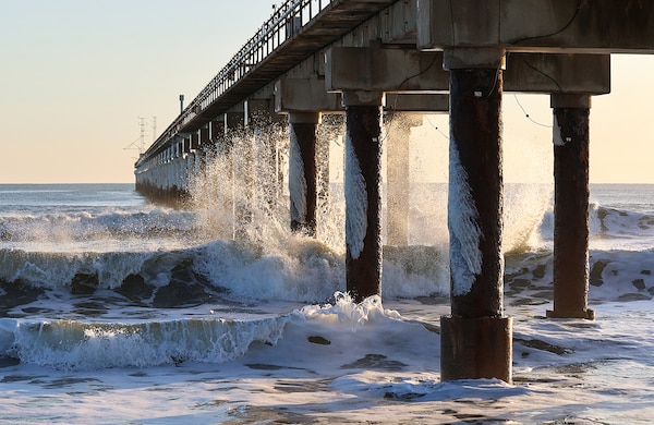 Frigid temperatures and blizzard-like conditions accompanied the high winds and heavy surf of a late January nor'easter in Duck, North Carolina. The sea spray and below-freezing air created a coating of ice on the support structure of the Field Research Facility’s pier. (Photo by Erin Diurba)