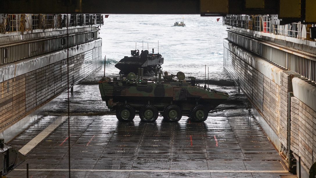 U.S. Marines with Alpha Company, 2nd Assault Amphibian Battalion, 2nd Marine Division operate an amphibious combat vehicle on the Whidbey Island-class dock landing ship USS Gunston Hall (LSD-44) during Naval Integration Training Package 2 off the coast of North Carolina, Dec. 4, 2025. NITP-2 is an amphibious, ship-to-shore, part of a larger training evolution certifying amphibious combat vehicle crewmen to safely and properly conduct combat operations with the ACV. (U.S. Marine Corps photo illustration by Lance Cpl. Dominic Trujillo)