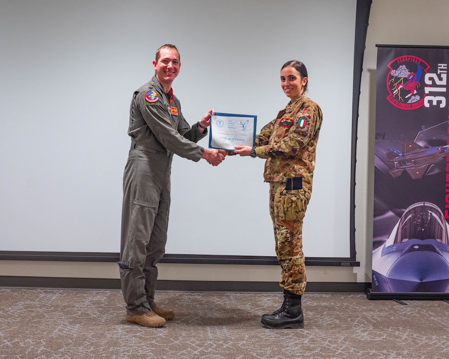 An Italian Air Force F-35 International Intelligence Formal Training Unit graduate, poses for a photo with U.S. Air Force Lt. Col. Christopher Umphres, 56th Operations Support Squadron commander, at Luke Air Force Base, Arizona.