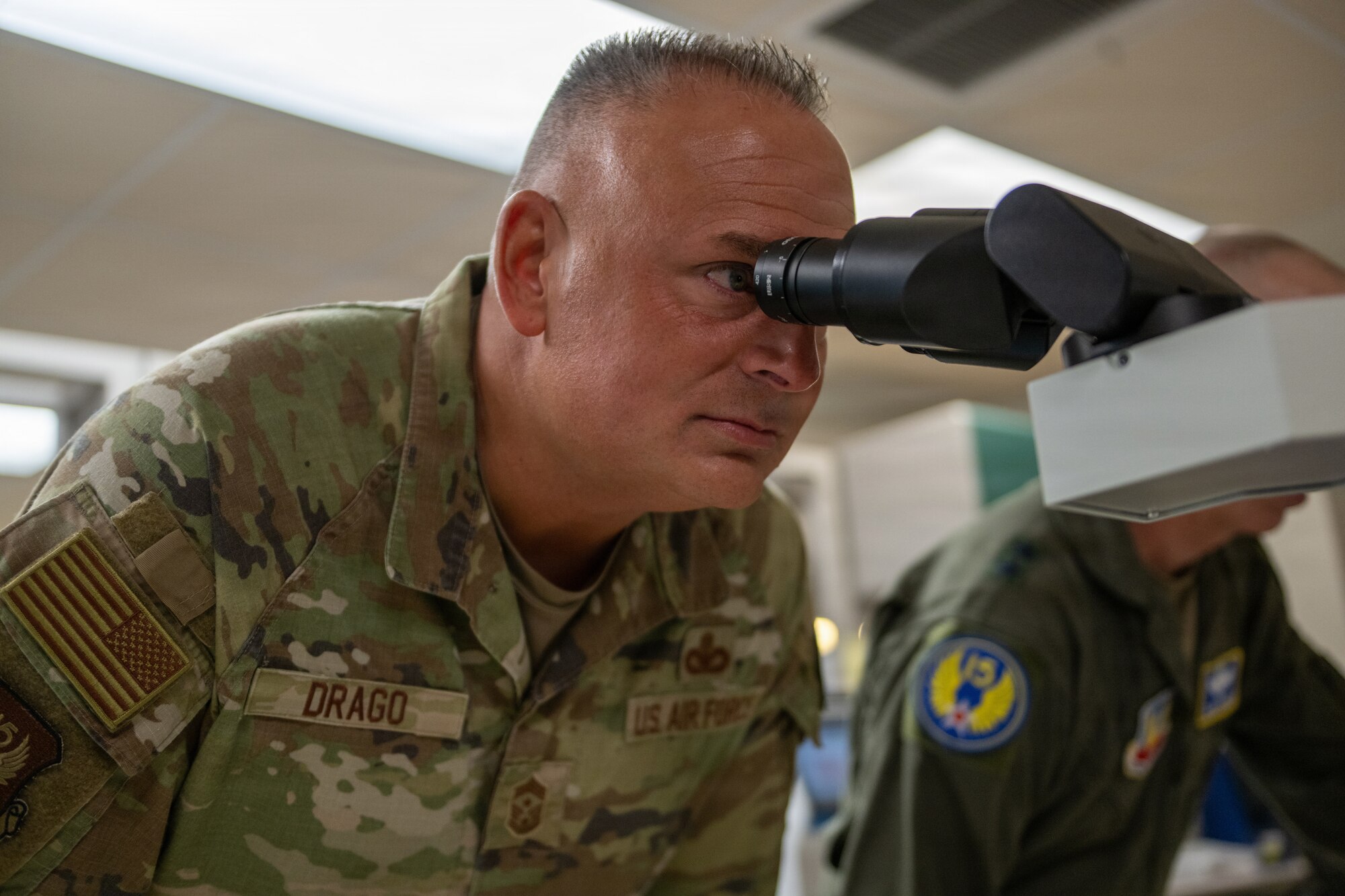 Photo of someone staring into microscope.