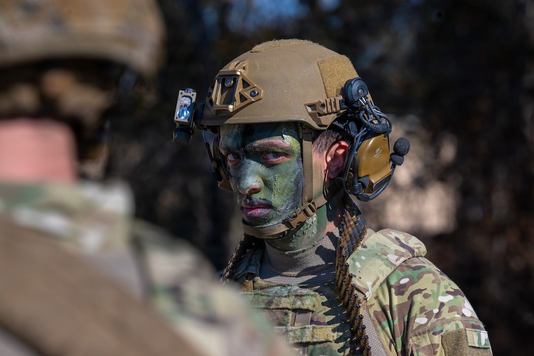 Photo of someone wearing camo paint looking into camera.