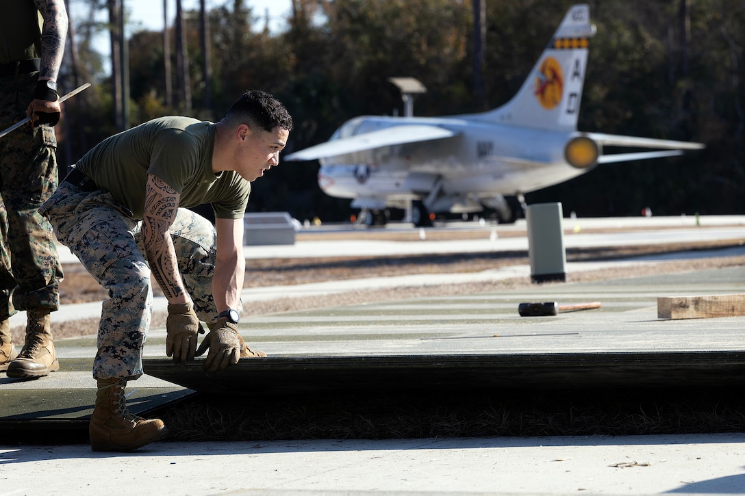 U.S. Marine Corps Gunnery Sgt. Eric Colon, Blount Island Command expeditionary airfield chief, lays aluminum matting Feb. 12, 2026, at the National POW/MIA Memorial and Museum site in Jacksonville, Florida. The expeditionary airfield matting, which was drawn from prepositioning sets at Marine Corps Support Facility Blount Island, will support the movement of a restored S-3 Viking aircraft onto the developing Legacy Plaza at the National POW/MIA Memorial and Museum site at Cecil Field. (Official U.S. Marine Corps photo by Dustin Senger)