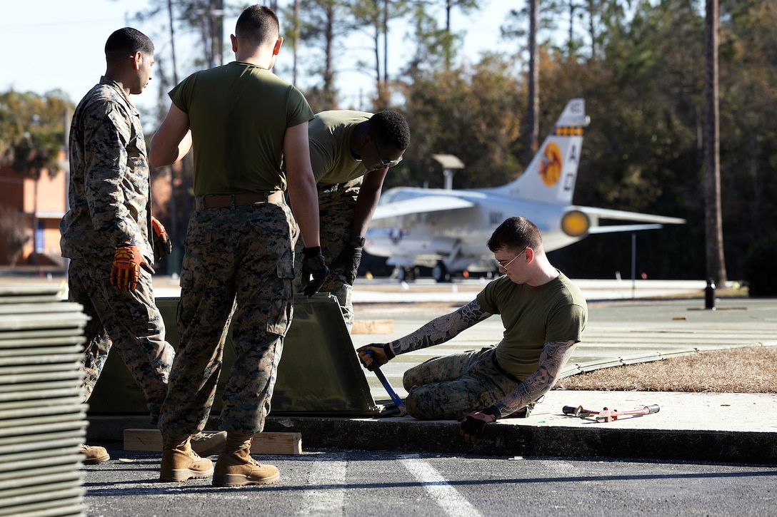 U.S. Marines assigned to Blount Island Command lay aluminum expeditionary airfield matting Feb. 12, 2026, at the National POW/MIA Memorial and Museum site in Jacksonville, Florida. The matting , which was drawn from prepositioning sets at Marine Corps Support Facility Blount Island, will support the movement of a restored S-3 Viking aircraft onto the developing Legacy Plaza at the National POW/MIA Memorial and Museum site at Cecil Field. (Official U.S. Marine Corps photo by Dustin Senger)