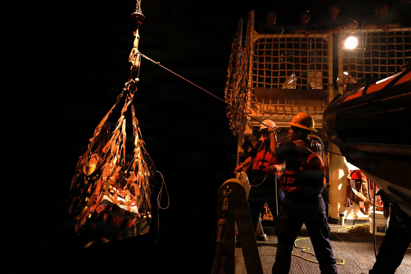 Coast Guard Cutter Seneca's crew uses a net and pulley system to transfer interdicted narcotics from the small boat to the ship in the Eastern Pacific Ocean, Jan 26, 2025. Following the end of the patrol, Seneca's crew offloaded approximately $133.5 million in illicit drugs at Port Everglades, Florida. (U.S. Coast Guard photo by Coast Guard Cutter Seneca's crew)