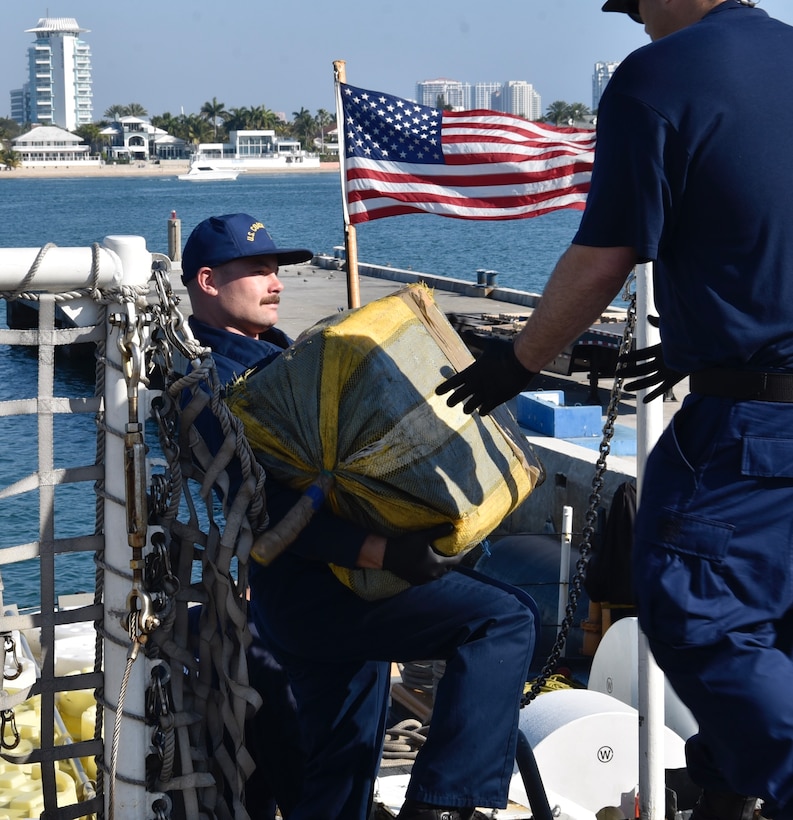 A USCGC Seneca (WMEC 906) crew member passes a bale of illicit drugs to another crew member during a drug offload at Port Everglades in Fort Lauderdale, Florida, Feb.13, 2026. The crew offloaded 17,750 pounds of illicit drugs worth more than $133 million as a result of four interdictions in the Eastern Pacific Ocean. (U.S. Coast Guard photo by Petty Officer 3rd Class Moriah Cannion)