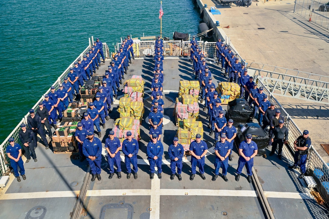 The crew of USCGC Seneca (WMEC 906) stand for a photo during a drug offload at Port Everglades in Fort Lauderdale, Florida, Feb. 30, 2025. The crew offloaded more than 17,750 pounds of illicit narcotics worth more than $133 million as a result of four interdictions in the international waters of the Eastern Pacific Ocean. (U.S. Coast Guard photo by Petty Officer 2nd Class Eric Rodriguez)