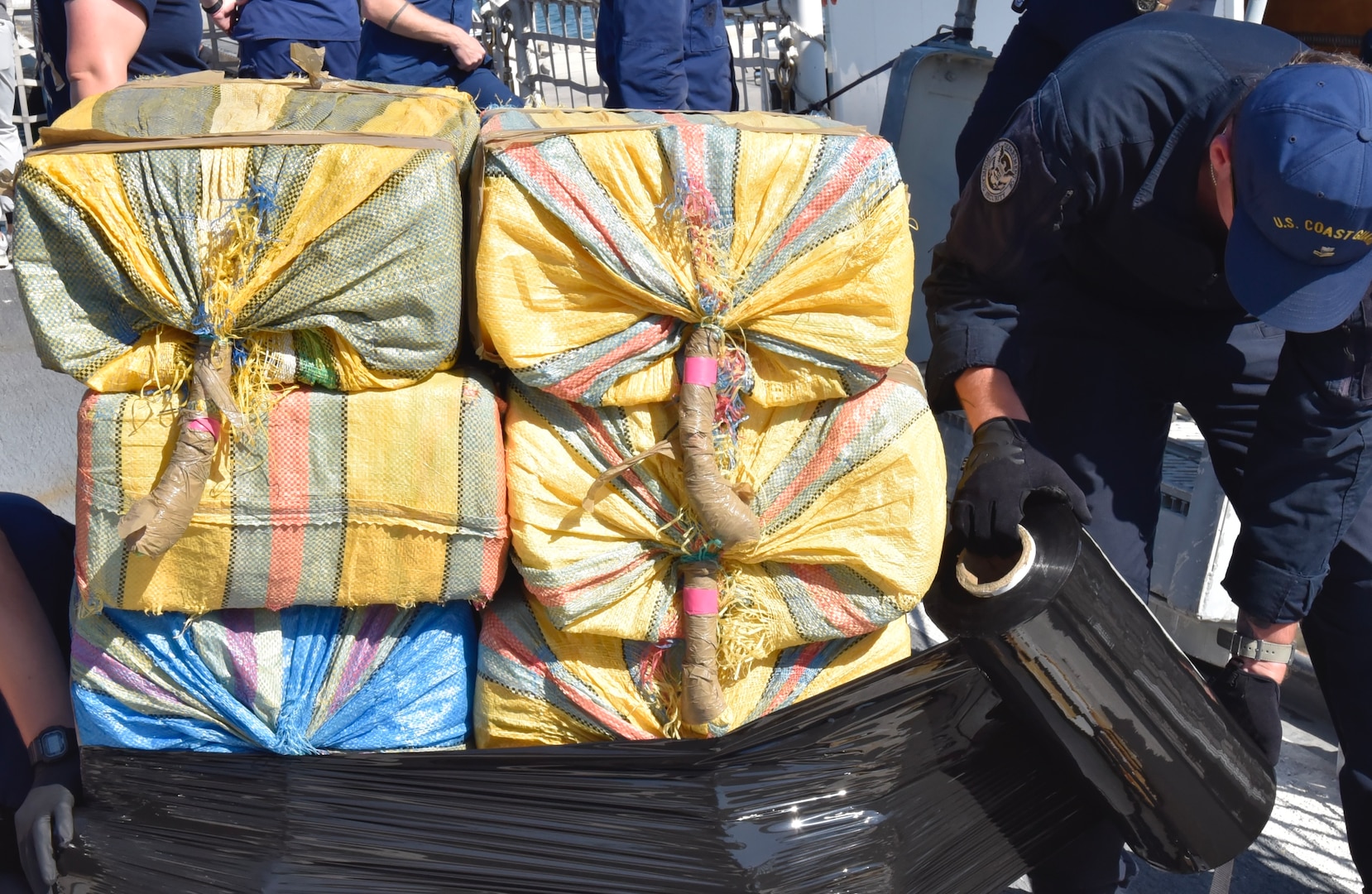 A USCGC Seneca (WMEC 906) crew member wraps bails of illicit narcotics during a drug offload at Port Everglades in Fort Lauderdale, Florida, Feb.13, 2026. The crew offloaded 17,750lbs of illicit drugs worth more than $133 million resulting from four interdictions in the Eastern Pacific Ocean. (U.S. Coast Guard photo by Petty Officer 3rd Class Moriah Cannion)