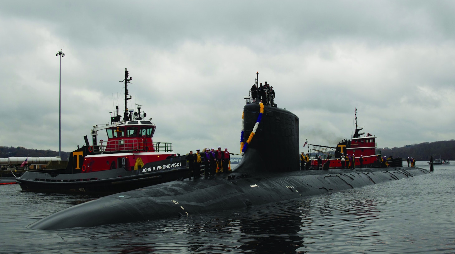 U.S. Navy nuclear submarine being guided by tugboats