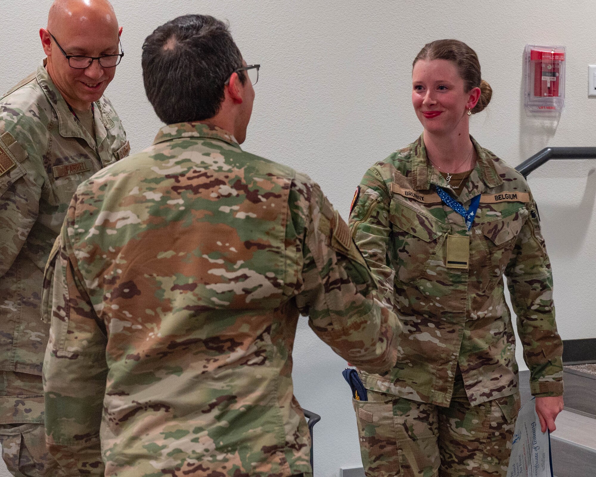 A Belgian Air Force F-35 International Intelligence Formal Training Unit graduate shakes hands with U.S. Air Force Maj. Christopher Castaneda, 56th Operations Support Squadron senior intelligence officer, Feb. 11, 2026, at Luke Air Force Base, Arizona.