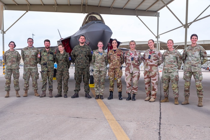 F-35 International Intelligence Formal Training Unit graduates and instructors, pose for a photo in front of an F-35A Lightning II, Feb. 11, 2026, at Luke Air Force Base, Arizona.