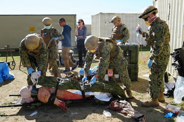 Cmdr. Daniel Fay (right), an emergency room physician, Lt. Ryan Buyeske (center), an emergency room nurse, and Hospital Corpsman 3rd Class Rian Meeks (left), a respiratory therapist, all assigned to Expeditionary Resuscitative Surgical System (ERSS) 21, Navy Reserve, package a simulated casualty for transport during an ERSS training at Camp Pendleton, California, Jan. 19-30, 2026.  The training, conducted by Naval Expeditionary Medicine Warfighter Development Center (NEMWDC), reinforces teamwork, patient movement, and efficient use of supplies in resource-constrained environments. (U.S. Navy photo by Petty Officer 2nd Class Leandra Mojica Rivera)
