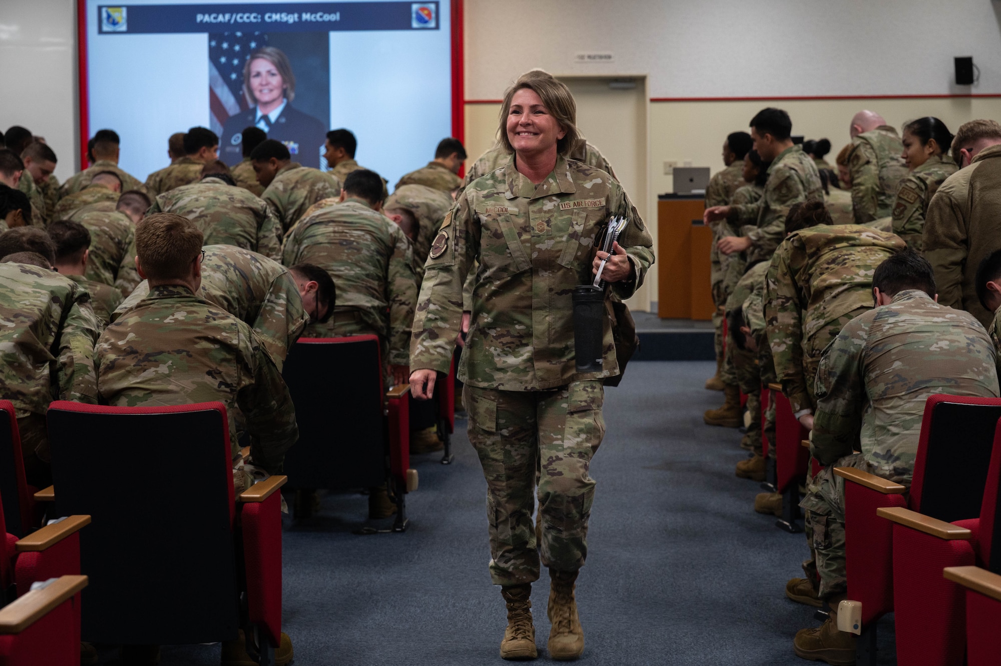 Chief Master Sgt. Katie McCool, Pacific Air Forces command chief, walks down an aisle at Airmen Leadership School