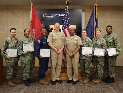Graduates of the Navy Medicine Readiness and Training Command Camp Pendleton 2026 Medical Service Corps Inservice Procurement Program cohort gather for a group photo with two of the course advisors following the graduation ceremony held in the Naval Hospital Camp Pendleton galley meeting room on Feb. 13, 2026. From left to right: Petty Officer 2nd Class Richard Villanueva, Petty Officer 2nd Class Unique Richardson, Petty Officer 1st Class Oyindamola Michael, Cmdr. Derrick Hoffman, NMRTC Camp Pendleton director for administration, Capt. Mark Murriel, NMRTC Camp Pendleton director for expeditionary medicine, Petty Officer 2nd Class Jamilah Agyei, Petty Officer 2nd Class Shannon Hagen, and Petty Officer 1st Class Luis Fernandez.