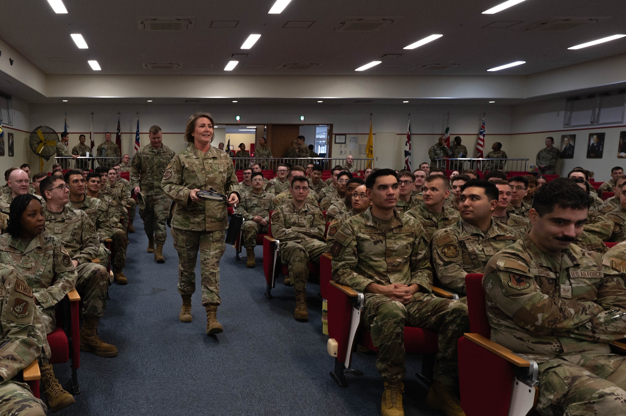 Chief Master Sgt. Katie McCool, Pacific Air Forces command chief, walks down an aisle at Airmen Leadership School