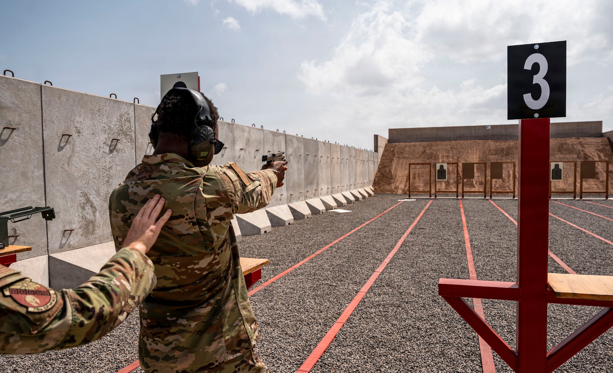 A U.S. Air Force Airman assigned to the 776th Expeditionary Air Base Squadron fires a handgun at the newly opened on-site small arms range at Chabelley Airfield