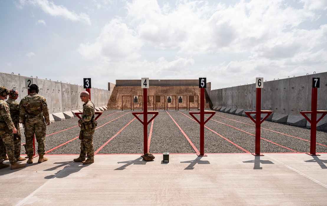 U.S. service members stand on the firing line during the opening of the first on-site small arms range at Chabelley Airfield