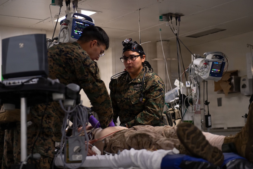260131-N-CM165-1172 Lt. j.g. Garcia Martinez, assigned to the 11th Marine Expeditionary Unit, I Marine Expeditionary Force, observes a simulated patient’s vital signs during a mass casualty drill aboard Wasp-class amphibious assault ship USS Boxer (LHD 4), Jan. 31, 2026. Boxer, flagship of the Boxer Amphibious Ready Group, is underway with the 11th Marine Expeditionary Unit in the U.S. 3rd Fleet area of operations conducting integrated training that enhances warfighting capabilities and tactical proficiency. (U.S. Navy photo by Mass Communication Specialist 2nd Class Normand Basque)