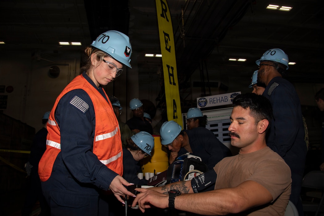 260130-N-FH842-1068 Hospital Corpsman 3rd Class Bridget Winters, of Colorado, left, collects vital sign measurements from Yeoman Seaman Oscar Peralta, of California, during a fire safety drill aboard Nimitz-class aircraft carrier USS Carl Vinson (CVN 70), Jan. 30, 2026. Carl Vinson is undergoing scheduled maintenance in its homeport of San Diego while remaining a combat-ready force dedicated to protecting and defending the United States. (U.S. Navy photo by Mass Communication Specialist 2nd Class Brianna Walker)