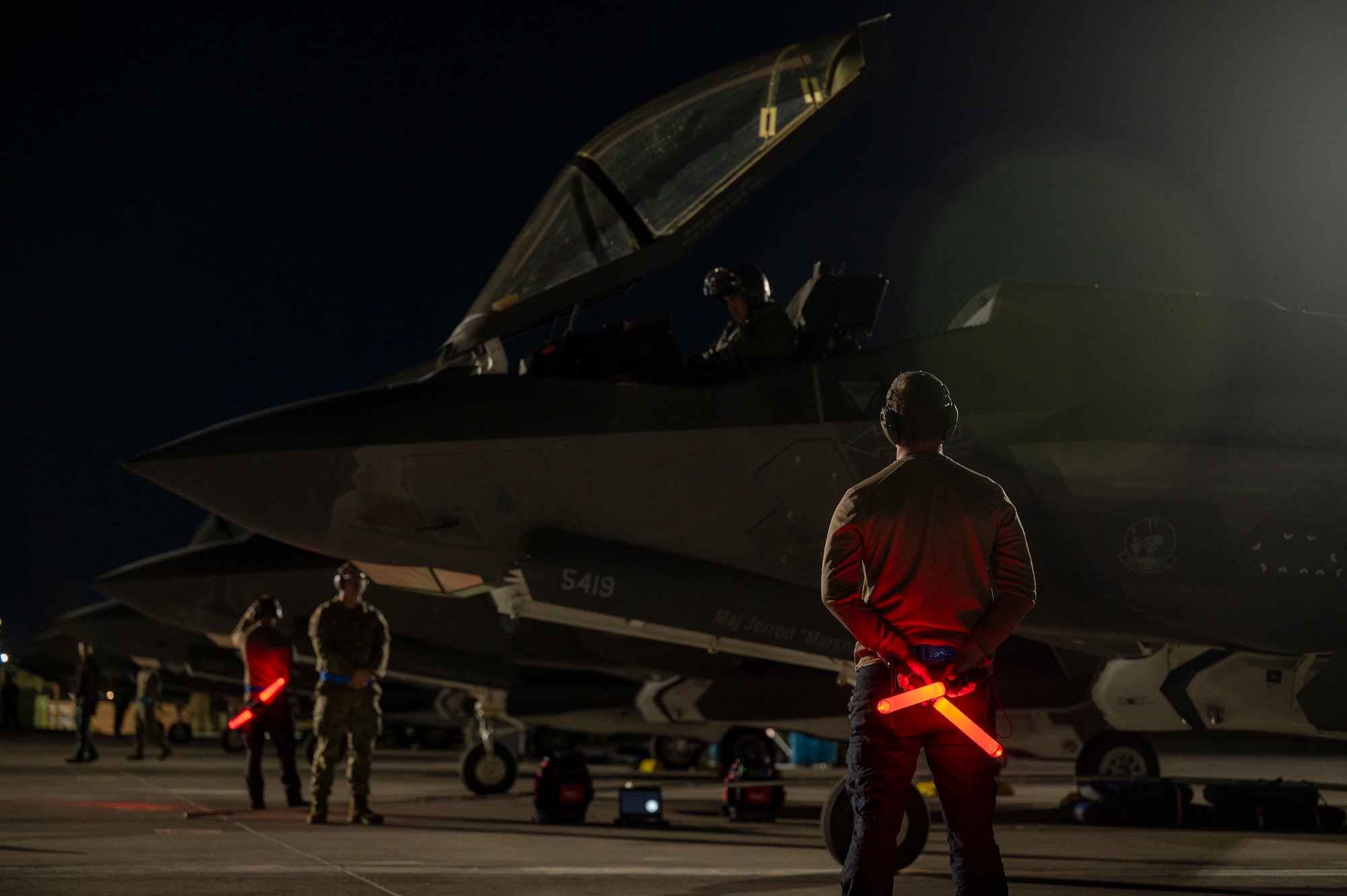 maintainers launch fighter jets at night
