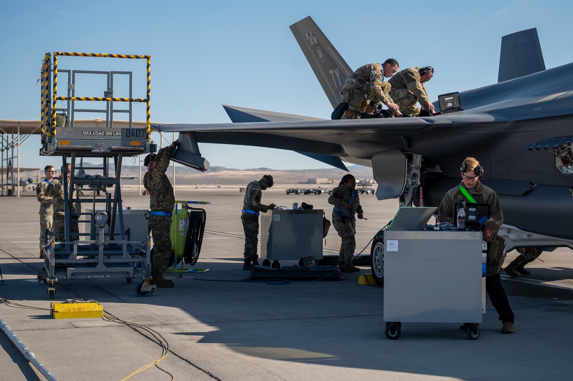 maintainers work on fighter jet