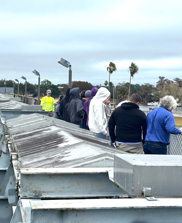 As part of a STEM outreach field trip, Jason Pritt, Lock Operator, guided students from Dunbar High School an up close tour of the WP Franklin Lock and Dam, including a view from atop the spillway. The visit introduced students  to another STEM-focused career path and provided insight into lock operations and engineering within the U.S. Army Corps of Engineers (USACE photo by John, Miracle, USACE Volunteer and former USACE Jacksonville District Lock Mechanic)