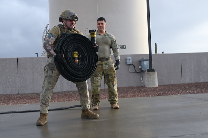 U.S. Air Force Staff Sgt. Keven Torres, 355th Logistics Readiness Squadron fuel service center supervisor, lifts a 100 foot collapsible fuel hose during Forward Area Refueling Point Team tryouts at Davis-Monthan Air Force Base, Ariz., Feb. 13, 2026. Once Airmen join the FARP team, they are eligible to conduct special operations refueling missions in austere environments and deployed locations in support of the Joint Force anywhere around the globe. (U.S. Air Force photo by Staff Sgt. Kahdija Slaughter)
