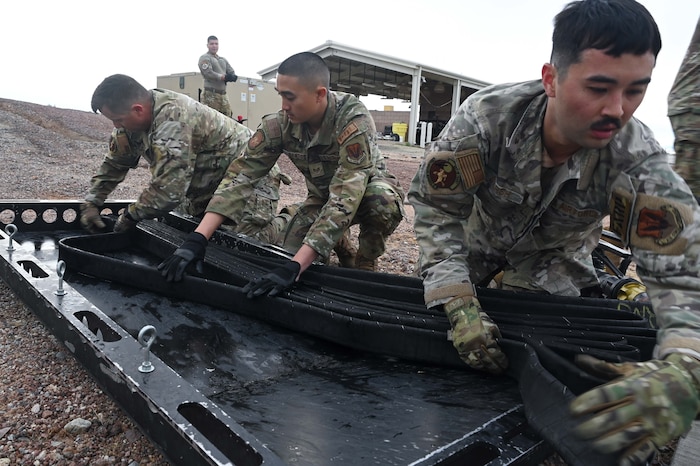 Airmen assigned to the 355th Logistics Readiness Squadron fuels service center fold a 300 foot collapsible fuel hose into a Forward Area Refueling Point sled during FARP team tryouts at Davis-Monthan Air Force Base, Ariz., Feb. 13, 2026. The team of Airmen reset the collapsible fuel hose, fuel hose squeegee, FARP water jug, and fire extinguisher at the end of each tryout. (U.S. Air Force photo by Staff Sgt. Kahdija Slaughter)