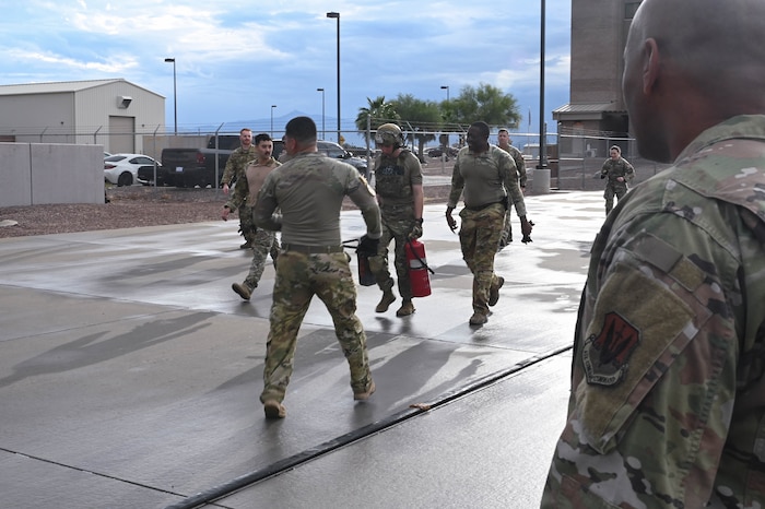 U.S. Air Force Chief Master Sgt. Kelvin Hatcher, 355th Wing Command Chief, watches Airmen assigned to the 355th Logistics Readiness Squadron fuels service center complete Forward Area Refueling Point Team tryouts at Davis-Monthan Air Force Base, Ariz., Feb. 13, 2026. The FARP team tryouts consist of fully extending a 300 foot collapsible fuel hose, conducting an s-fold, prepping the hose for refueling, then rolling up the hose and carrying it back to the starting point in less than 15 minutes. (U.S. Air Force photo by Staff Sgt. Kahdija Slaughter)