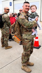 Illinois Army National Guard Spc. Wyatt Collier holds his son, 1-year-old Waylon Collier, after returning from deployment.