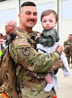 Illinois Army National Guard Spc. Wyatt Collier holds his son, 1-year-old Waylon Collier, after returning from deployment.