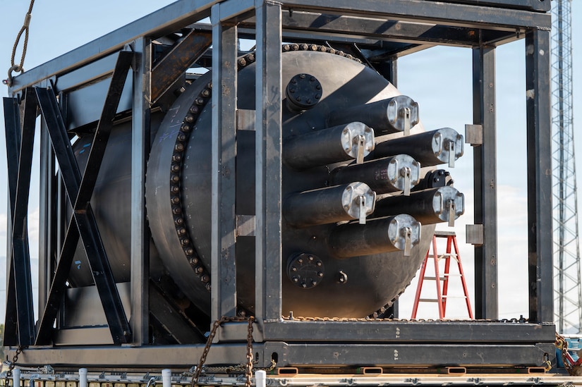 A containerized nuclear power reactor sits secured within a reinforced steel transport frame.