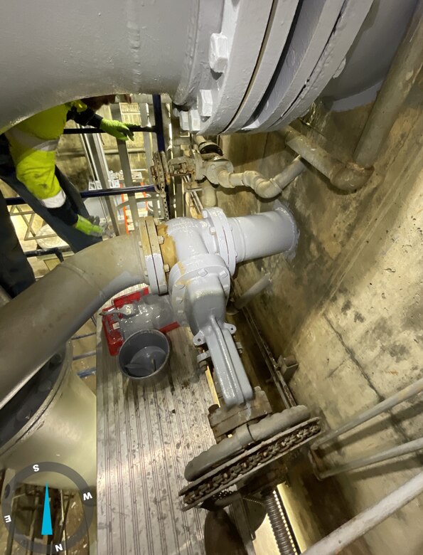 An aerial view of a large grey pipe with concrete walls surrounding.