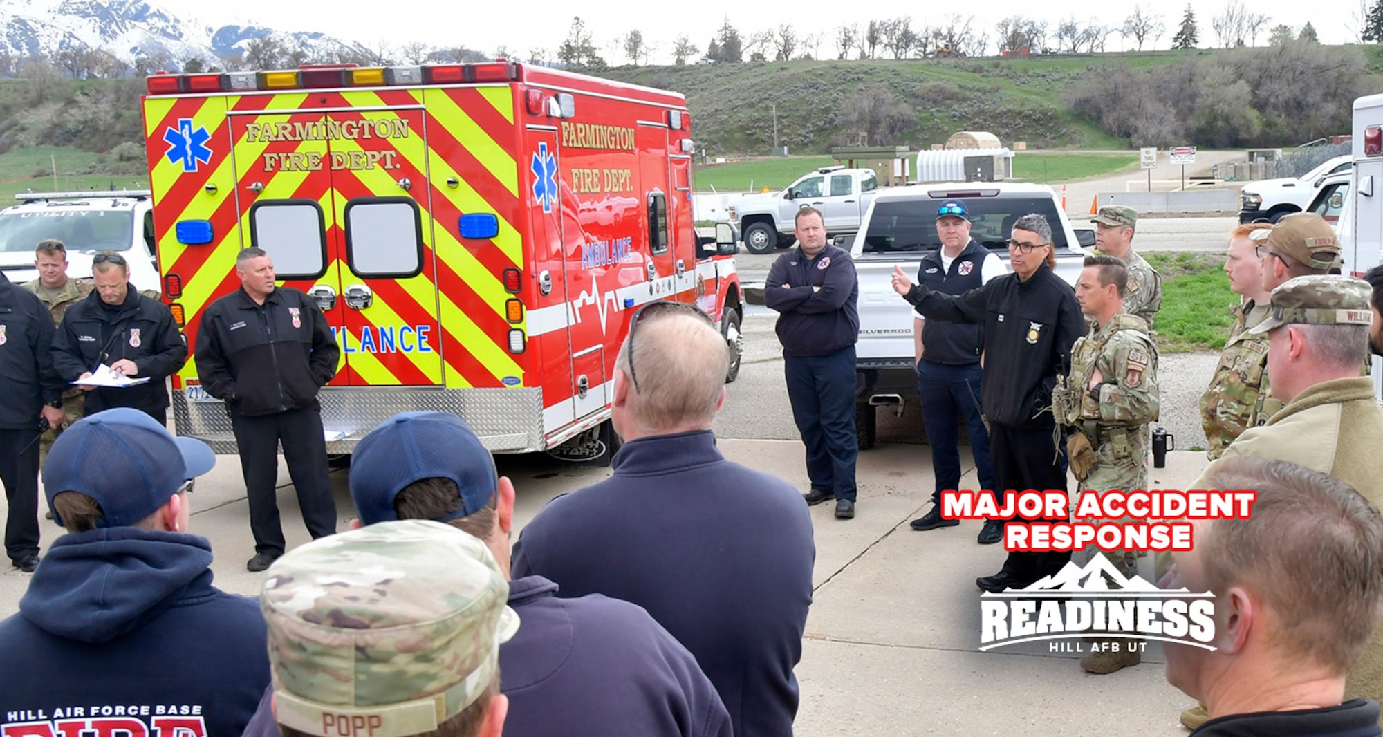 Emergency responders huddle next to an ambulance.