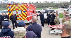Emergency responders huddle next to an ambulance.