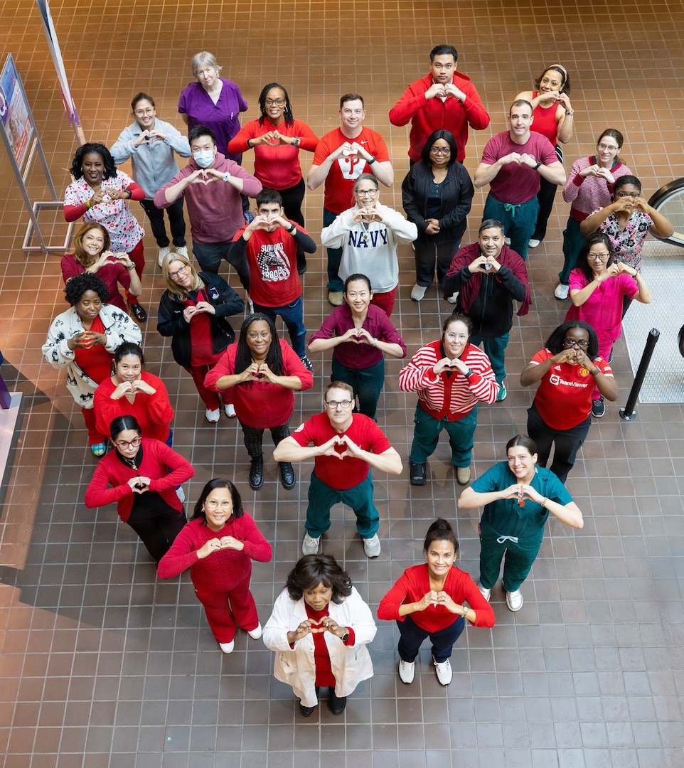 People pose in a heart-shape formation.