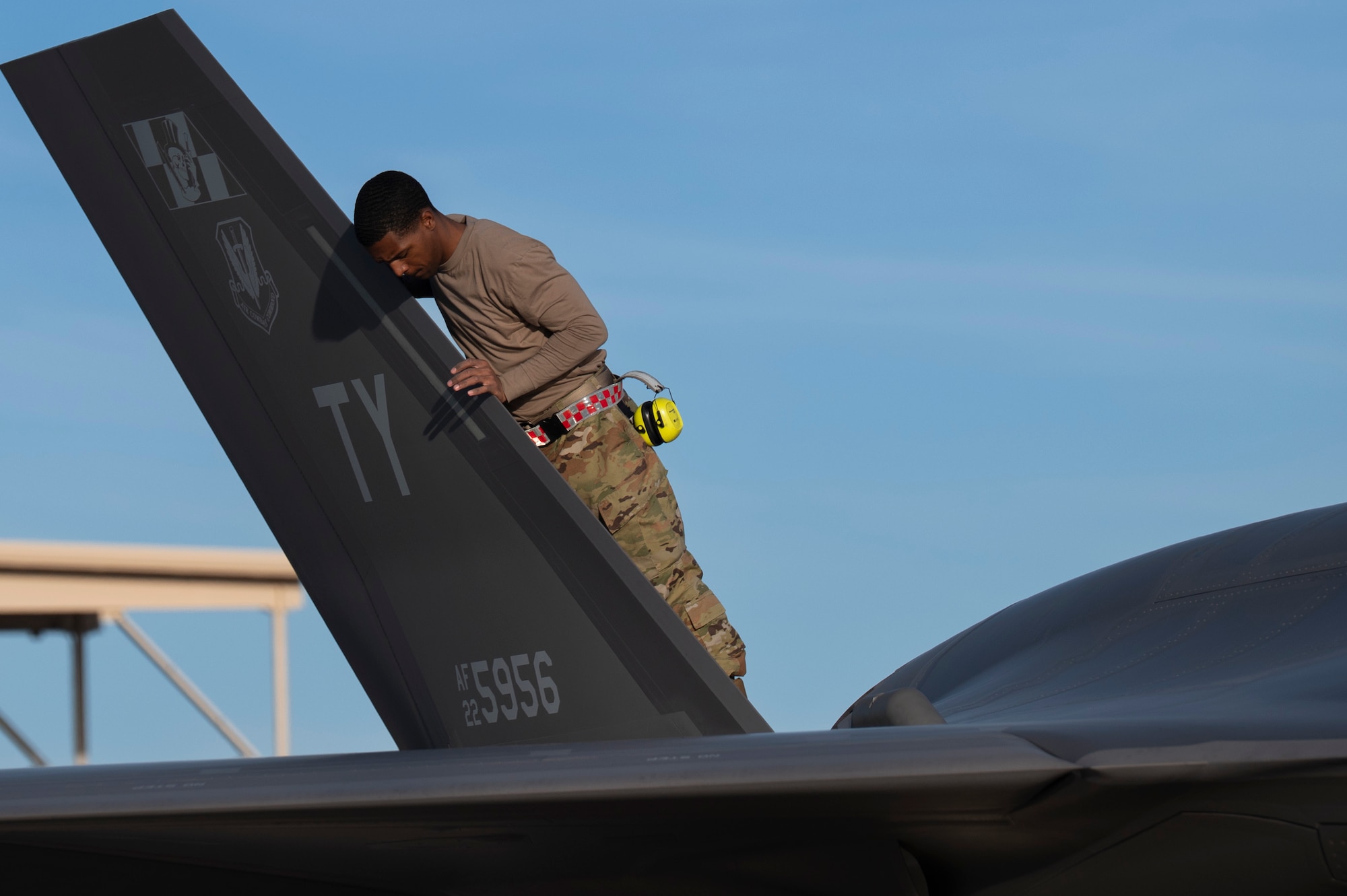 maintainer stands on fighter jet
