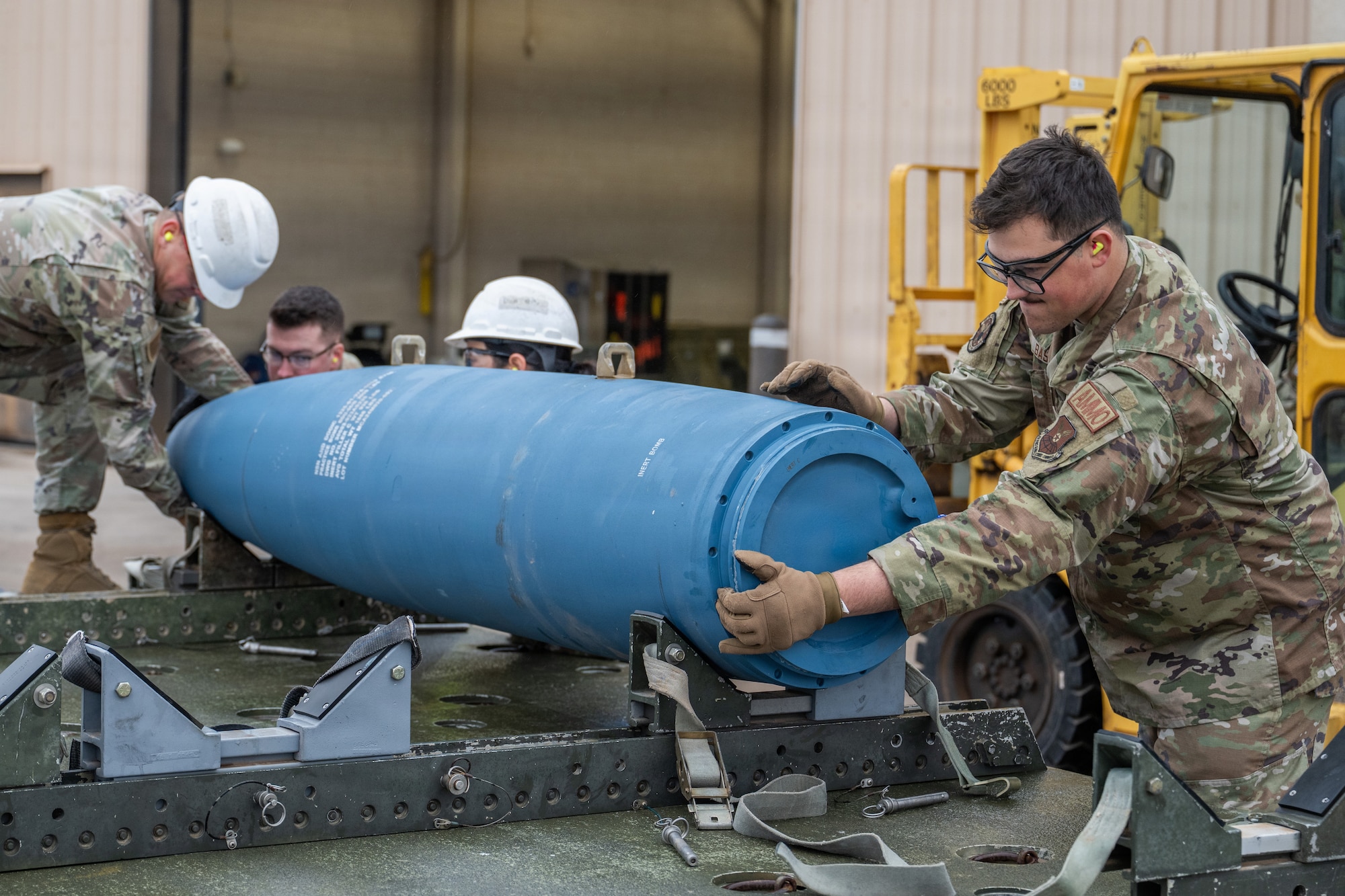 U.S. Airmen assigned to the 7th Munitions Squadron load Joint Direct Attack Munitions onto a trailer during Exercise DARK ASCENT at Dyess Air Force Base, Texas, Jan. 23, 2026. The Combat Readiness Exercise evaluated the 7th Bomb Wing’s ability to generate and sustain combat airpower through realistic deployment and installation defense scenarios. (U.S. Air Force photo by Airman 1st Class Caleb Schellenberg)