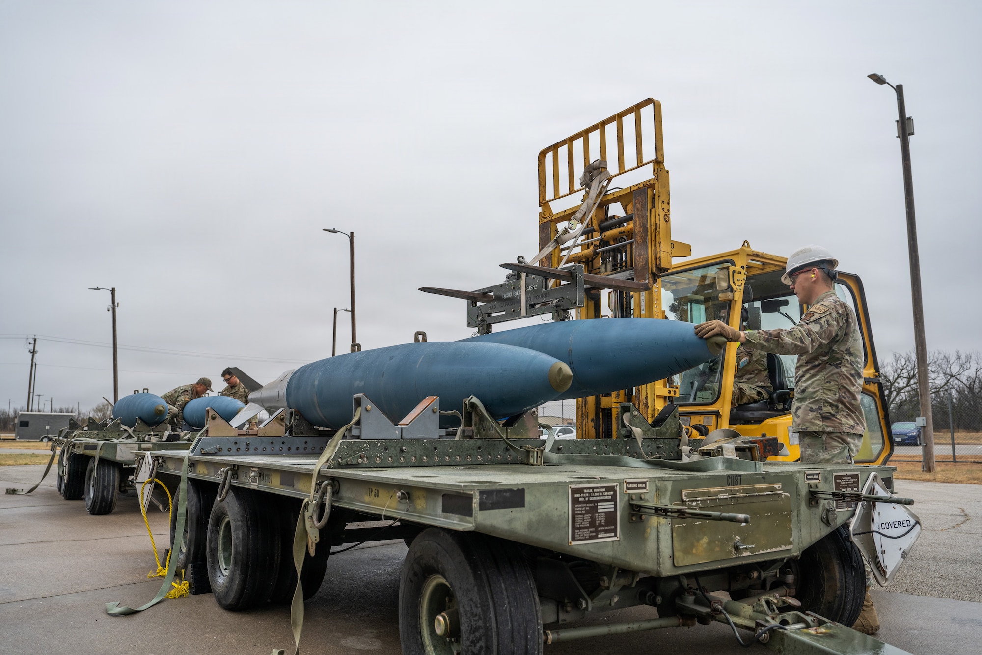 U.S. Airmen assigned to the 7th Munitions Squadron load Joint Direct Attack Munitions onto a trailer during Exercise DARK ASCENT at Dyess Air Force Base, Texas, Jan. 23, 2026. The Combat Readiness Exercise tested the 7th Bomb Wing’s capacity to rapidly generate munitions support in a simulated contested environment. (U.S. Air Force photo by Airman 1st Class Caleb Schellenberg)