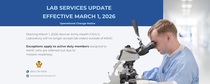 White male in a lab coat looking into a microscope.