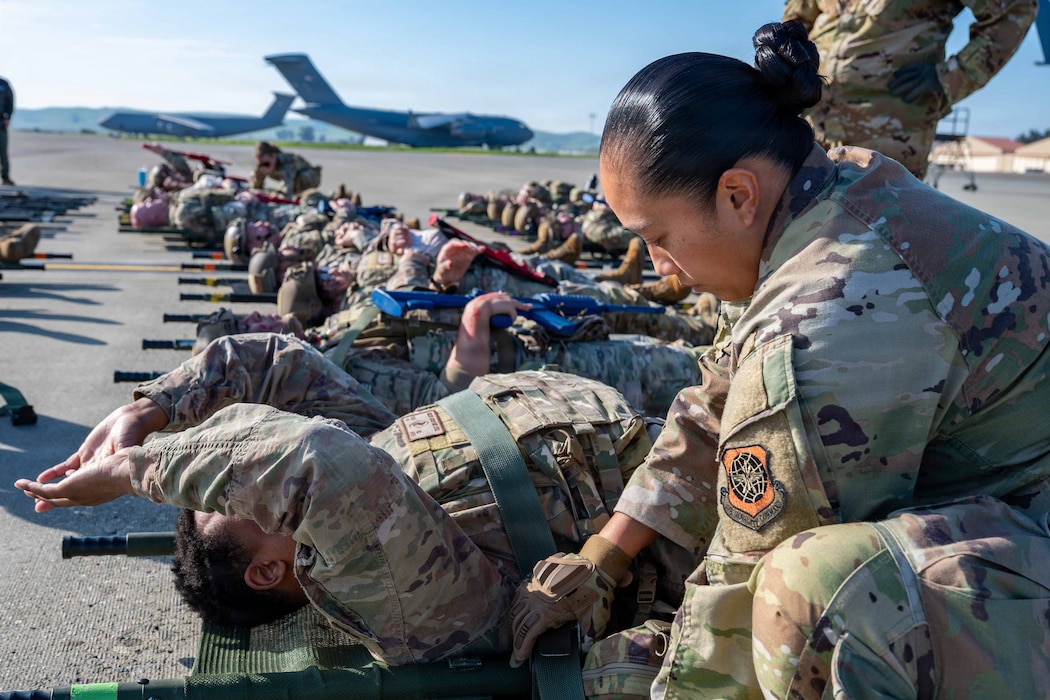 Flight nurse gives simulated medical care on flightline.