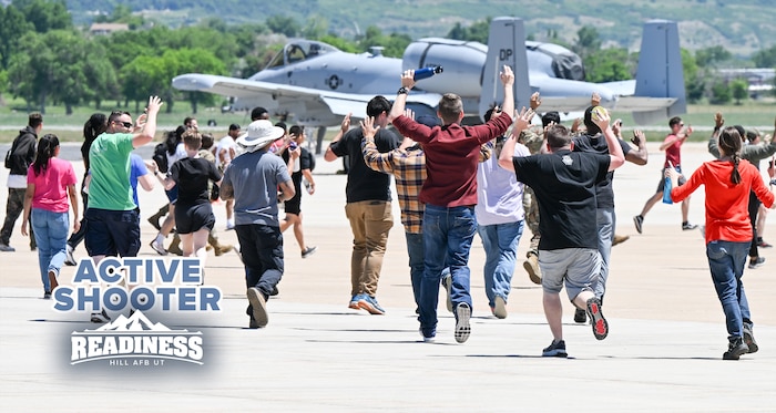 Participants running toward law enforcement with their hands raised.