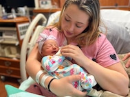 Woman holding a newborn baby in a hospital bed
