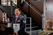 A woman holds an award plaque.