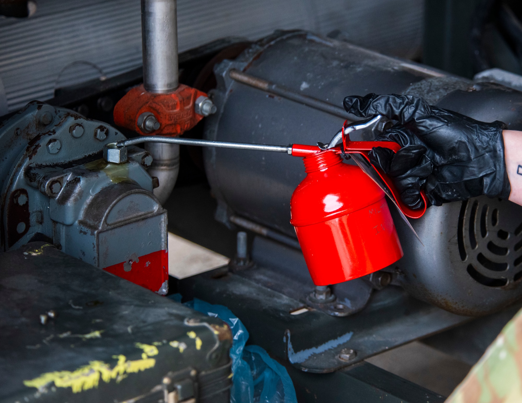A U.S. Airman applies oil to an equipment