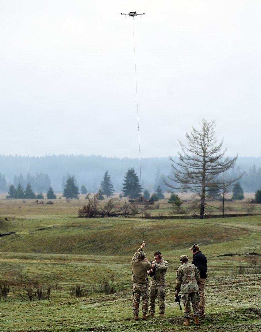 Capt. Ryan Hafley, commander, Headquarters and Headquarters Company, 96th Troop Command, attaches a new target to a unmanned aerial system during the FIFA Field-Ready Range Day at Joint Base Lewis-McChord, Wash., Feb. 11, 2026.